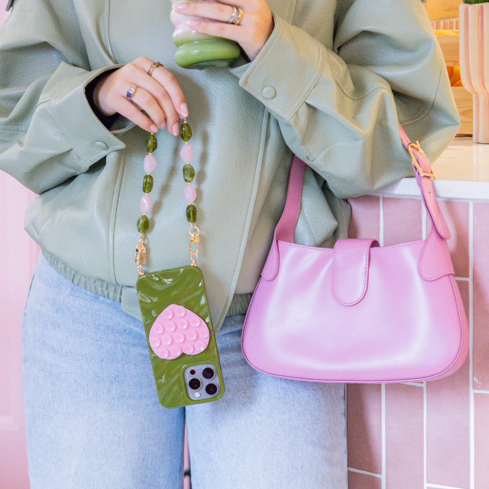 Rose Quartz Short telefoonbandje met roze en groene steenaccenten, gedragen om de pols.