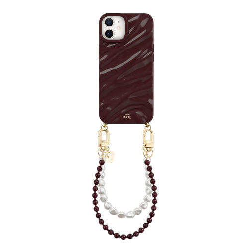 Glanzende bordeauxrode iPhone 12 hoes met golvend patroon, bevestigd aan een parelkoord met bordeauxrode en witte parels.