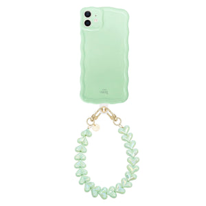 Glossy wavy sage green iPhone 11 case with a detachable funky hearts cord.