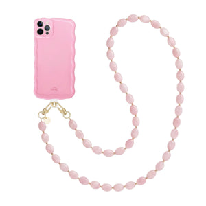 Glossy Wavy Case Bubble Blush iPhone 12 Pro met een lichtroze golvend hoesje en een lang Ocean koord van roze ovale kralen.