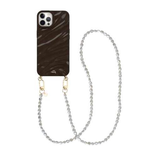Glanzende bruine iPhone 12 Pro hoes met golvend patroon en een lang Pearlfection koord met witte parels.
