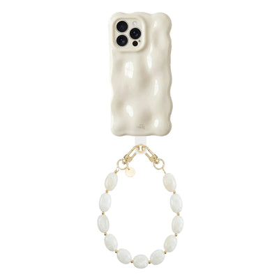Crèmekleurige Bubbly case Cloud Dancer met golvende textuur en kort Ocean Sand koord met parelachtige kralen.