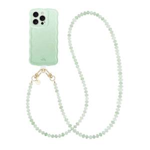 Glanzende, golvende saliegroene telefoonhoes met een lang Dusty Green kralenkoord.