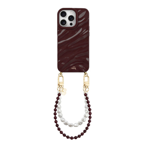 Bordeauxrode glanzende iPhone 16 Pro hoes met golvend patroon en twee koorden: bordeauxrode en witte parels.