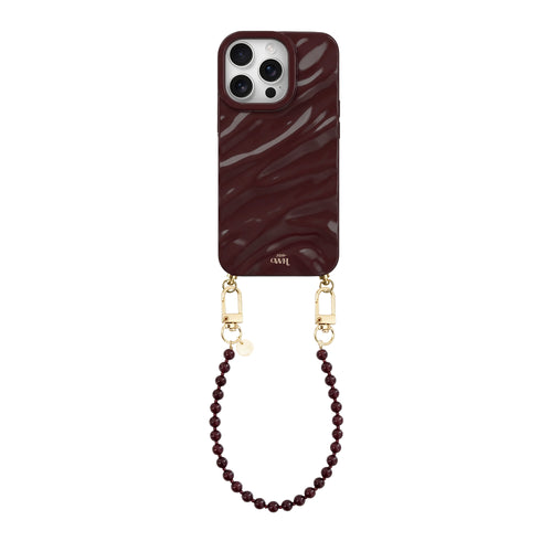 Glanzende bordeauxrode iPhone 15 Pro hoes met golvend design en bijpassend kort kralenkoord met gouden haakjes.