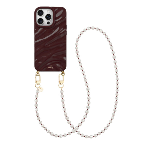 Glanzend bordeauxrode iPhone 16 Pro hoesje met golvend design en lang Burgundy Pearl parelkoord.