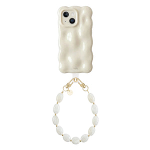 Crèmekleurige iPhone 13 hoes met golvend design en kort Ocean Sand koord met ovale parels.