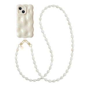 Crèmekleurige iPhone 14 hoes met golvende vorm en lang Ocean Sand koord met parelketting.