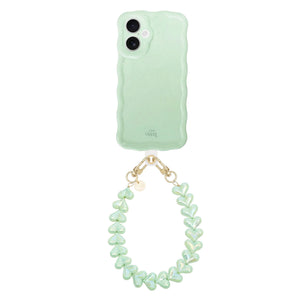 Glossy Wavy Case Sage Sorbet iPhone 16 met Funky Hearts koord, saliegroen en glanzend.