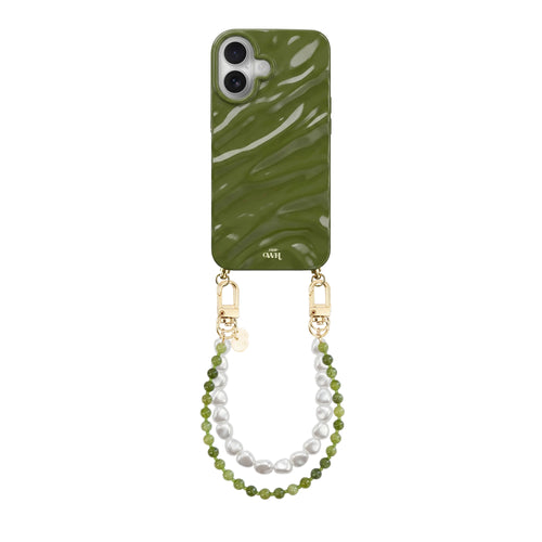 Glanzend donkergroen iPhone 16 hoesje met golvend design, gouden haakjes, en twee koorden: olijfgroen en wit parelkoord.