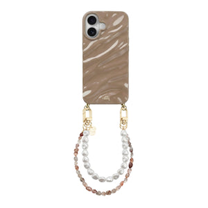 iPhone 16 Glaze Cord Case in Soft Taupe with a wavy design, attached to two pearl and bead wrist cords.