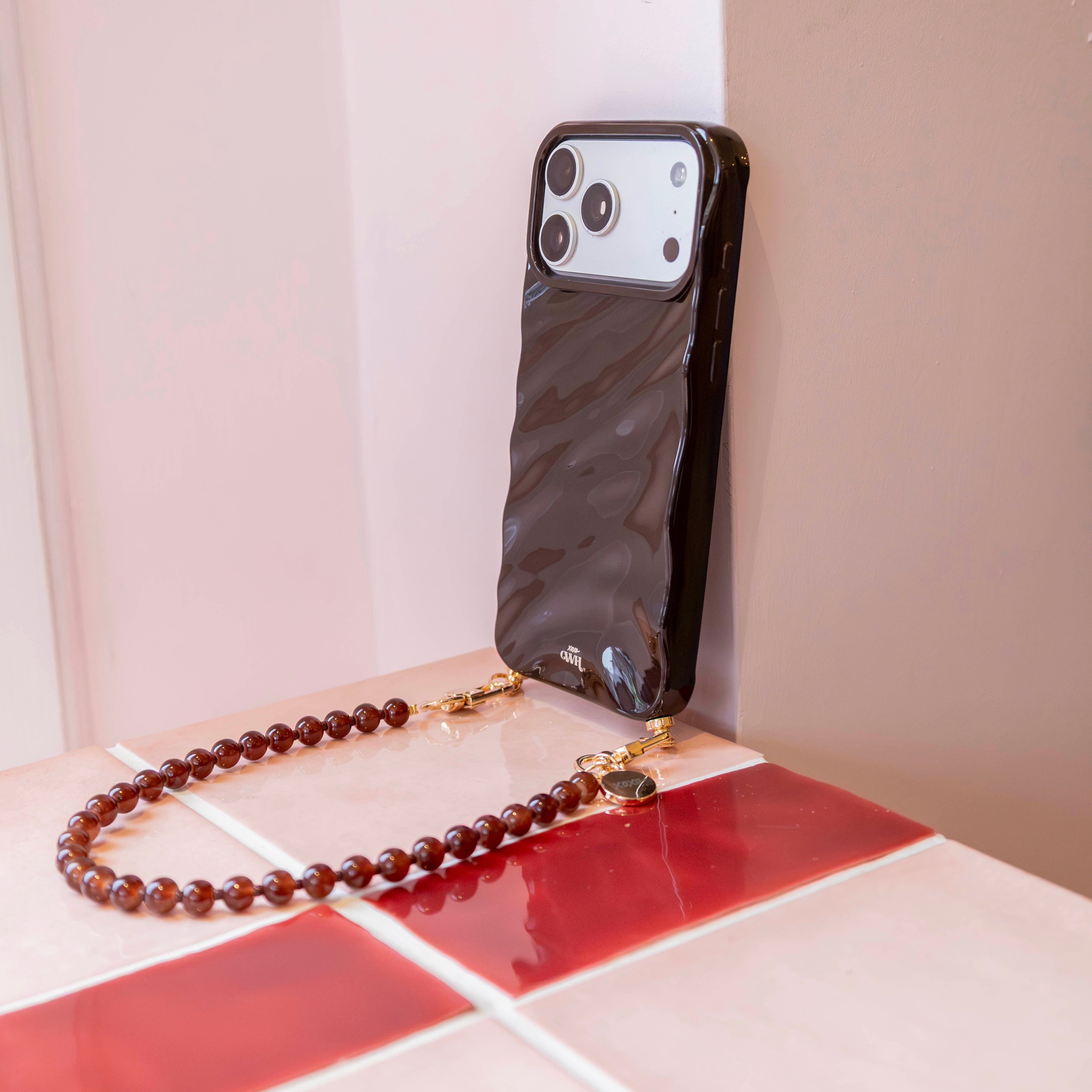 Glanzend bruin iPhone 16 Glaze Cord Case met golvend design en kort Brown Sugar kralenkoord.