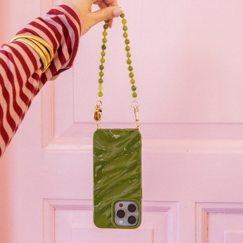 Glanzende Deep Olives iPhone 15 Plus Glaze Cord Case met kort kralenkoord en gouden haakjes.