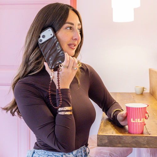 Vrouw met glanzende bruine Glaze Cord Case en kort Brown Sugar koord, drinkt koffie.