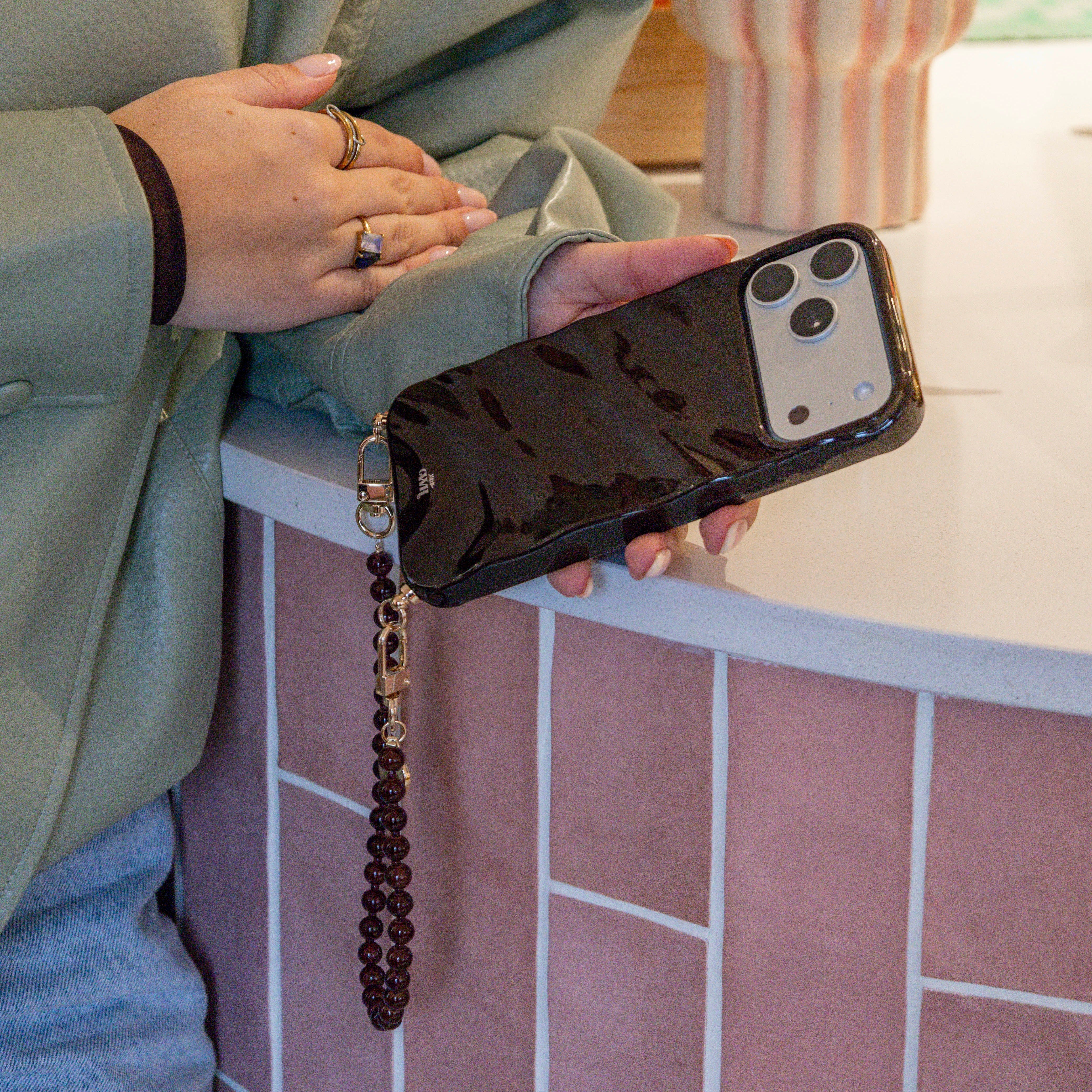 Glanzende bruine iPhone 14 Pro Glaze Cord Case met kort Brown Sugar koord en gouden haakjes.