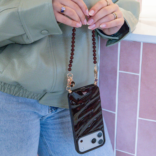 Glanzende bruine Glaze Cord Case met Brown Sugar koord, gedragen door een persoon.