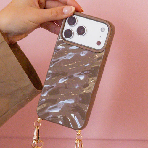 Hand houdt taupe iPhone 11 Glaze Cord Case met glossy finish en gouden hardware.