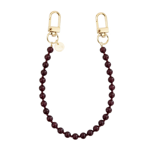 Kort Burgundy Muse koord met glanzende bordeauxrode kralen en twee gouden karabijnhaken.
