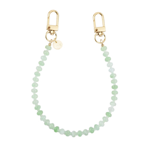 Kort Dusty Green kralenkoord voor telefoon met gouden karabijnhaken en merklabel.