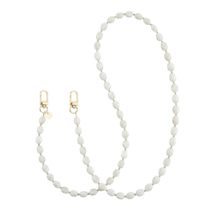 Lange Ocean Sand telefoonkoord met witte kralen en gouden details, inclusief twee gouden sluitingen.