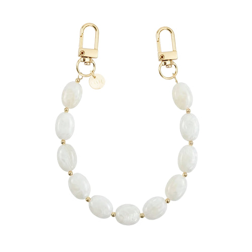 Kort Ocean Sand polskoord met witte ovale kralen, gouden details en twee karabijnsluitingen.