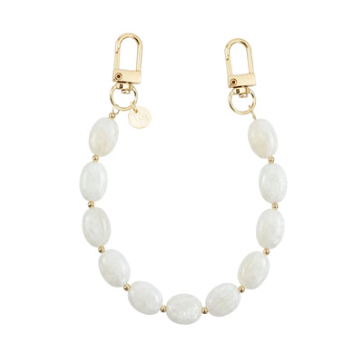 Kort Ocean Sand polskoord met witte ovale kralen, gouden details en twee karabijnsluitingen.